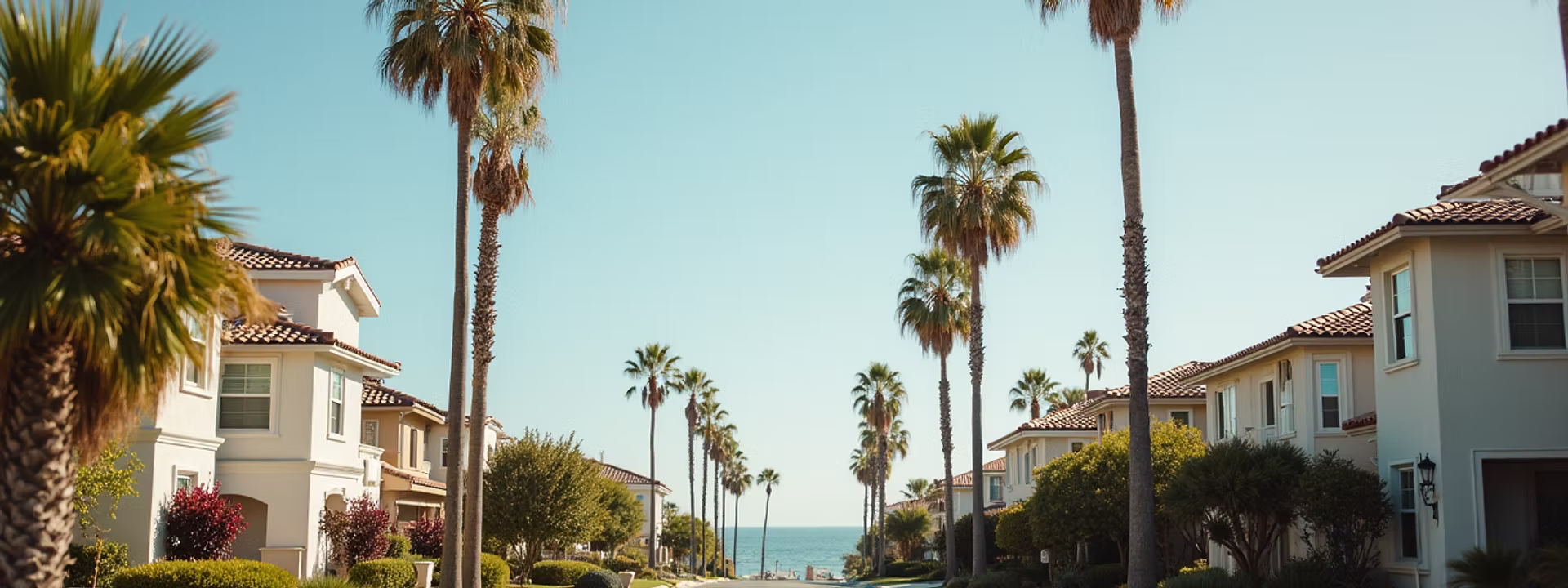 Eye-level view of a coastal Southern California neighborhood with homes and palm trees